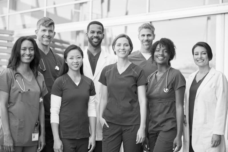 Smiling medical team standing together outside a hospital At Three Oaks Hospice, we believe in a holistic approach to end-of-life care